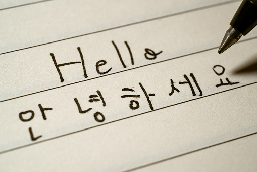 Principiante idioma coreano aprendiz escribiendo Hello Word en caracteres coreanos en un cuaderno macro Shot photo