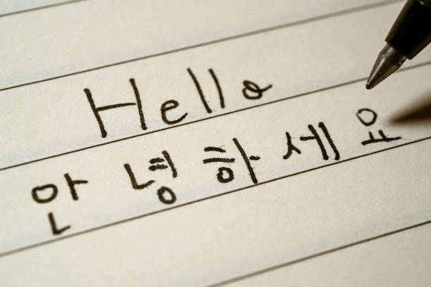 Beginner Korean language learner writing Hello word in Korean characters on a notebook macro shot Beginner Korean language learner writing Hello word in Korean characters on a notebook macro shot korean stock pictures, royalty-free photos & images