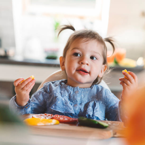 istock Cute baby making a mess out of vegetables, having fun 1143900161