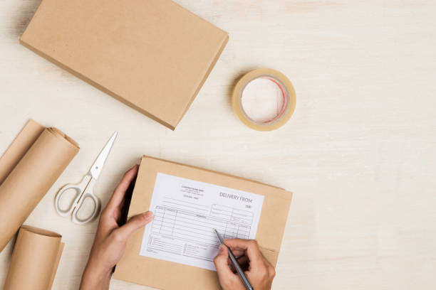 istock Top view of deliveryman making notes in delivery receipt at table. Return to vendor 1143904974