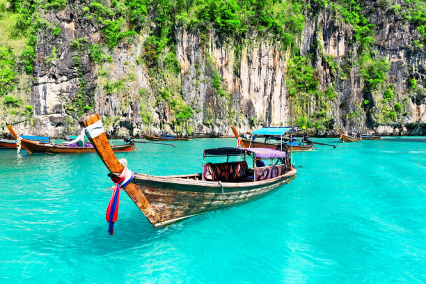 Maya bay on Koh Phi Phi Leh island, Thailand. Famous Maya Bay lagoon at Ko Phi Phi Leh Island with thai traditional longtail boat, surrounded by limestone cliffs in Krabi Province, Andaman Sea. Thailand koh poda stock pictures, royalty-free photos & images