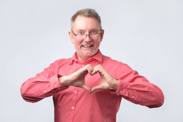 istock Mature man showing heart with fingers at studio 1143911869
