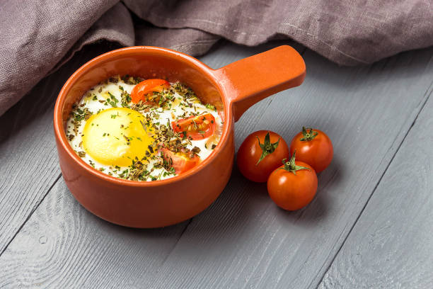 istock Portioned baked eggs in ceramic cocotte on gray wooden table, breakfast. 1143916495