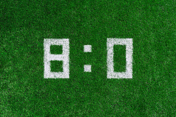 istock Football score 8:0.White numbers eight and zero are drawn on the green grass,creative scoreboard 1143920184