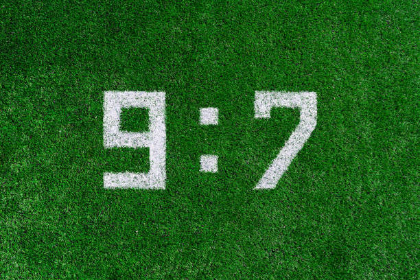 istock Football score 9:7.White numbers nine and seven are drawn on the green grass,creative scoreboard 1143920722