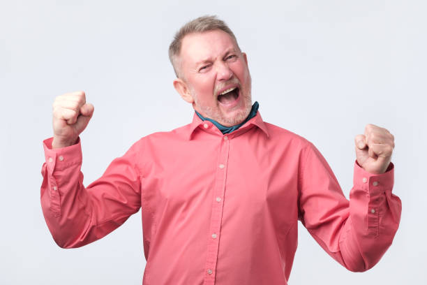 istock Senior man very glad to win, gesturing with fists. 1143923944
