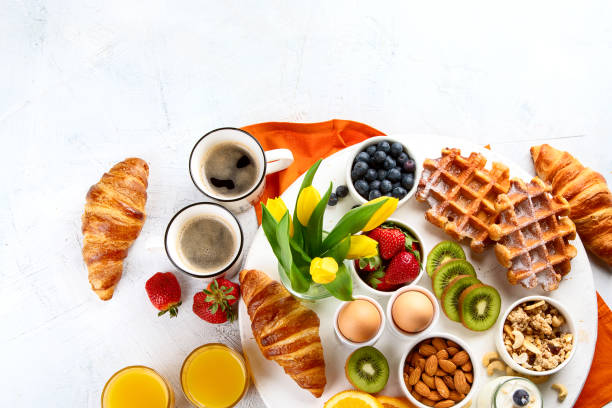 istock Breakfast table with eggs, berries, yogurt,waffle and croissant 1143924042