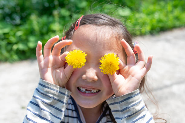 istock Girl playing with flowers 1143924581