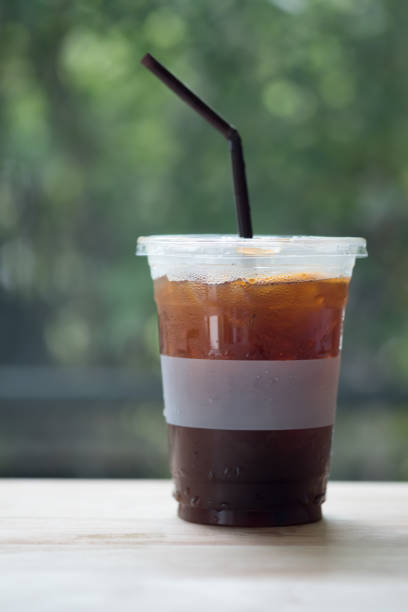 istock Iced Americano coffee on wood table with nature background 1143925260