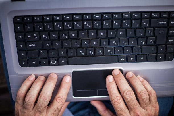 istock Senior hand on laptop 1143925501