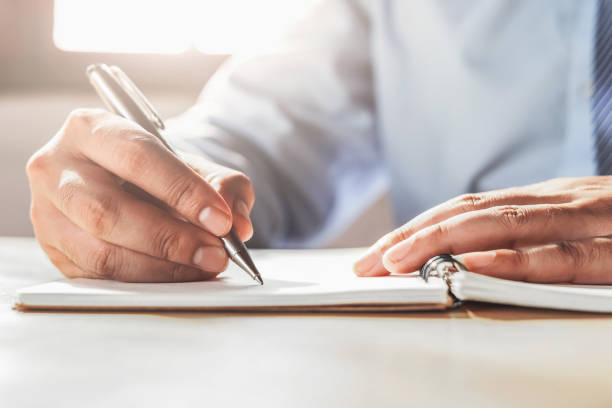 istock businessman writing on note book in office 1143927047