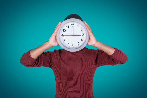 istock African American guy with clock near face 1143929586