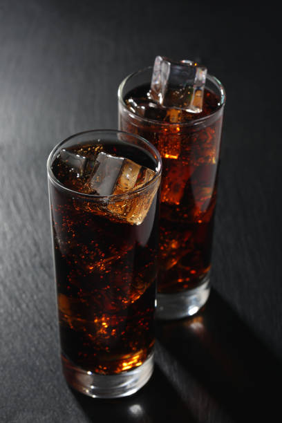 istock Glasses of cola on black board. Closeup 1143930496
