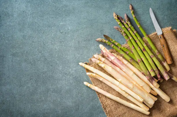 Green and white fresh asparagus on table
