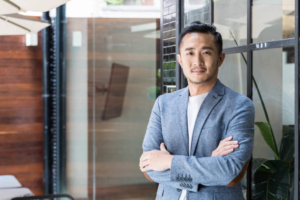 uomo d'affari asiatico di successo in uno spazio di coworking moderno - gray hair immagine foto e immagini stock