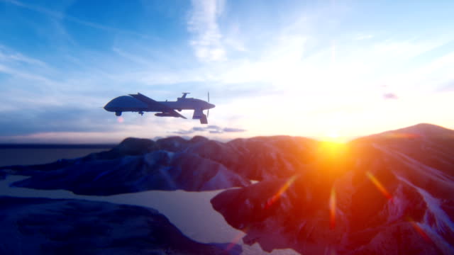 A military drone flies over a desert mountain plain at sunrise. The concept of military weapons.
