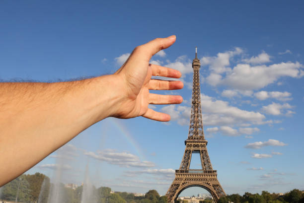 istock hand of man who takes Eiffel Tower 1143941543