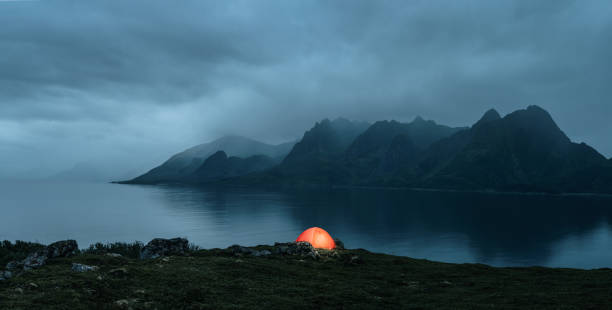 Illuminated tent at the lofoten islands Illuminated tent at the lofoten islands on the rainy evening with copy space fjord photos stock pictures, royalty-free photos & images