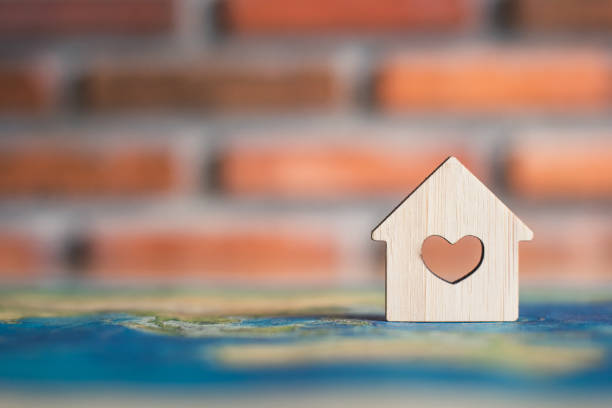 istock Wooden house on world map 1143943118