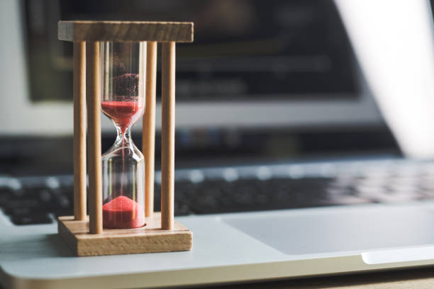istock sand clock timer on laptop .symbol of time 1143943259