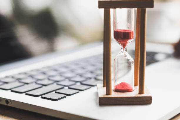 istock sand clock timer on laptop .symbol of time 1143943277