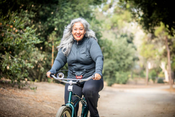 senior mujer mexicana cabalgando bicicleta - overweight women weight loss fotografías e imágenes de stock