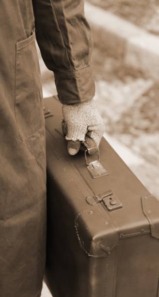 istock poor man with old leather suitcase with sepia toned effect 1143945188