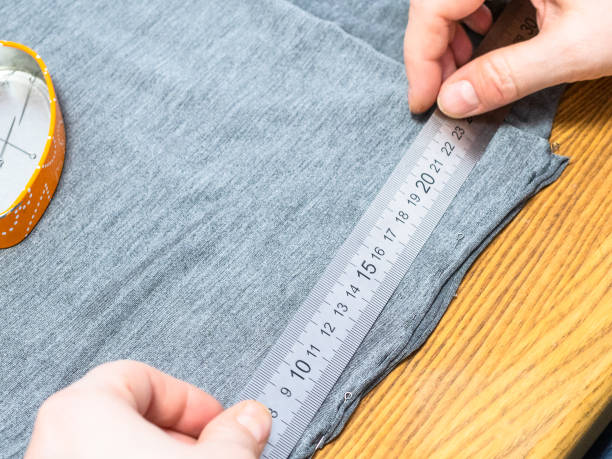 istock dressmaker marks a gray fabric with ruler 1143950983