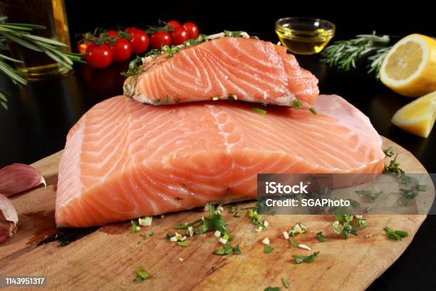 Fresh Raw Salmon Fillet On Cutting Board Stock Photo - Download Image Now - Cherry Tomato, Cilantro, Cooking Oil