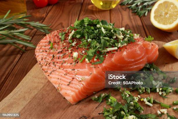 Fresh Raw Salmon Fillet On Cutting Board Stock Photo - Download Image Now - Cherry Tomato, Cilantro, Cooking Oil