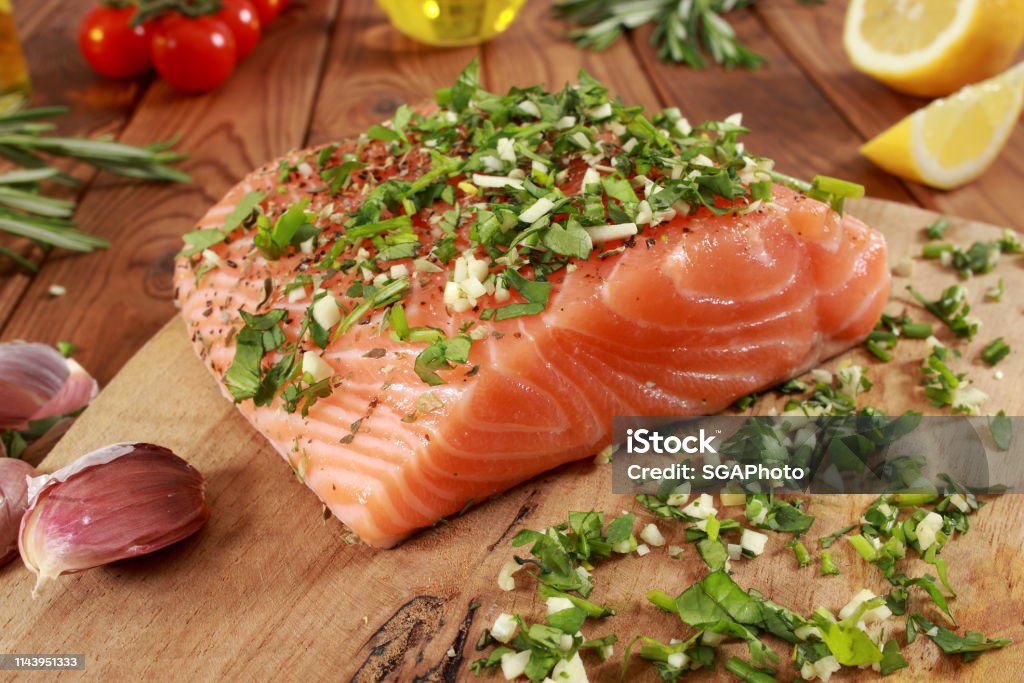 Fresh raw Salmon Fillet on cutting board Cherry Tomato Stock Photo