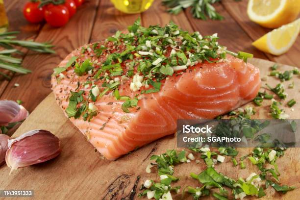 Fresh Raw Salmon Fillet On Cutting Board Stock Photo - Download Image Now - Cherry Tomato, Cilantro, Cooking Oil