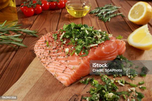 Fresh Raw Salmon Fillet On Cutting Board Stock Photo - Download Image Now - Cherry Tomato, Cilantro, Cooking Oil