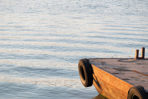Old metal pontoon with the used tire for prevent from bumping in the local river.
