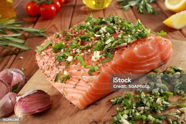 Fresh Raw Salmon Fillet On Cutting Board Stock Photo - Download Image Now - Cherry Tomato, Cilantro, Cooking Oil