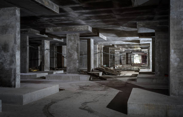 Concrete construction of underground level of building. Panorama inside the modern construction site in dark. Contemporary structure under construction with concrete walls, pillars, ceiling and floor.