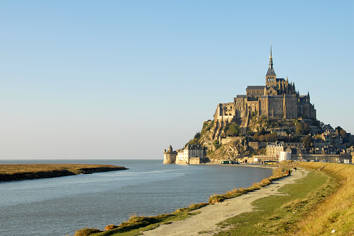 Le Mont-Saint-Michel, France - Apr 12, 2024: Abbey of Le Mont-Saint-Michel. Long distance view. Sunny spring day. Selective focus