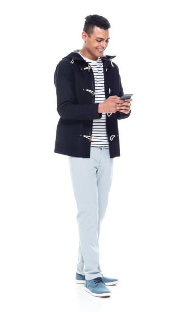 istock Handsome African American male standing on white background - texting on smart phone 1143961746