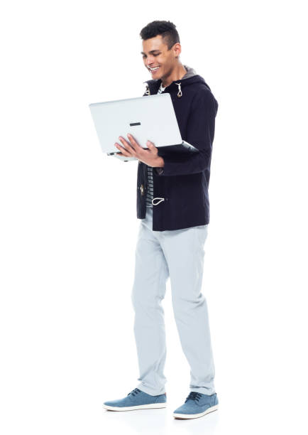 istock Handsome African American male standing on white background - using a laptop 1143961765