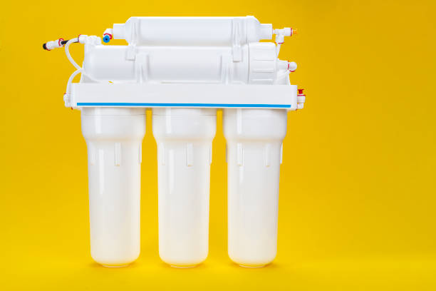 new osmosis water filter on a yellow background. - impurities imagens e fotografias de stock