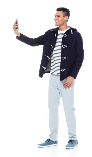 istock Handsome African American male standing on white background - taking a selfie 1143961782