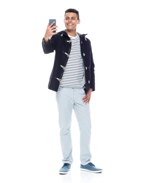 istock Handsome African American male standing on white background - taking a selfie 1143961812