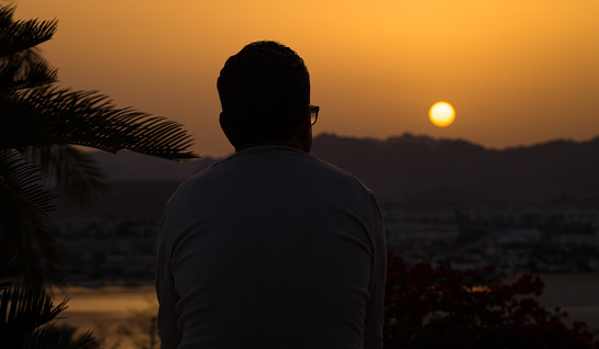 A man admires the sunset over the mountains in Egypt. Sharm El Sheikh.