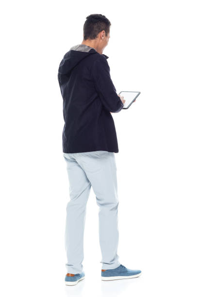 istock Handsome African American male standing on white background - using tablet 1143961952