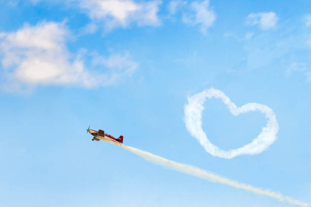 Concept of love Concept of confession in love. Small red airplane draw a valentine in a blue sky. words in the sky stock pictures, royalty-free photos & images