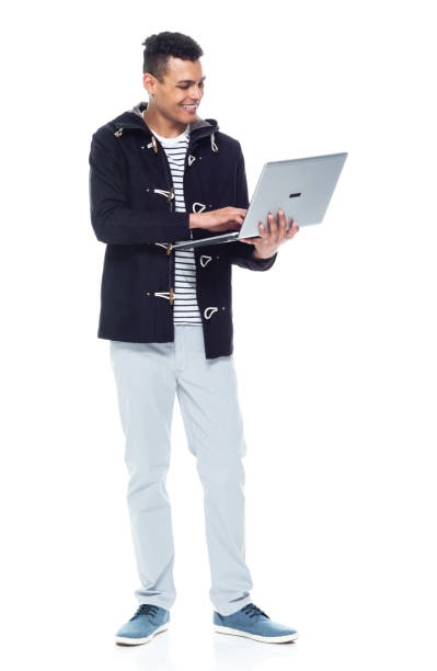 istock Handsome African American male standing on white background - using a laptop 1143961976