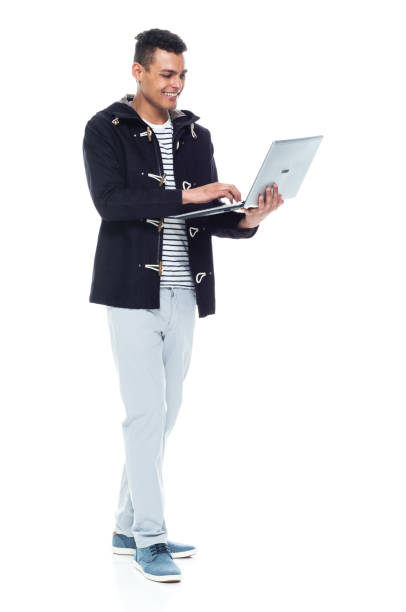 istock Handsome African American male standing on white background - using a laptop 1143962004