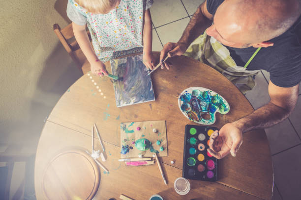 istock Father and son painting together 1143963595