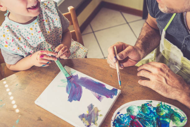 istock Father and son painting together 1143963752