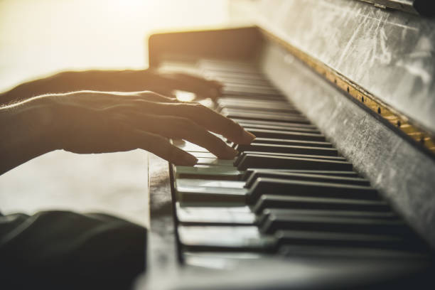 le mani di una vecchia suonano il pianoforte. vista ravvicinata della texture della pelle e dei tasti del pianoforte. - piano piano key orchestra close up foto e immagini stock